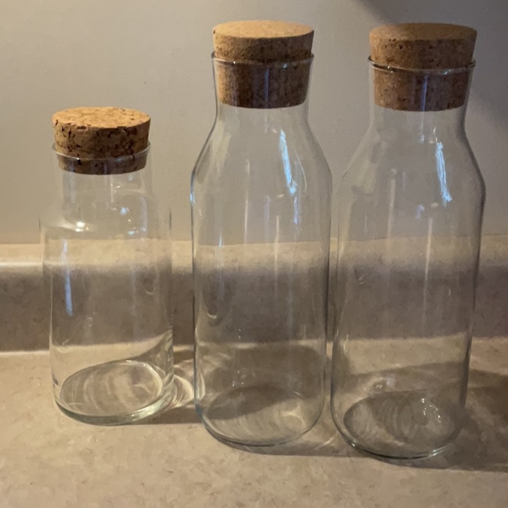 Set of Three Glass Bottles with Cork Lids. Great counter top storage.
